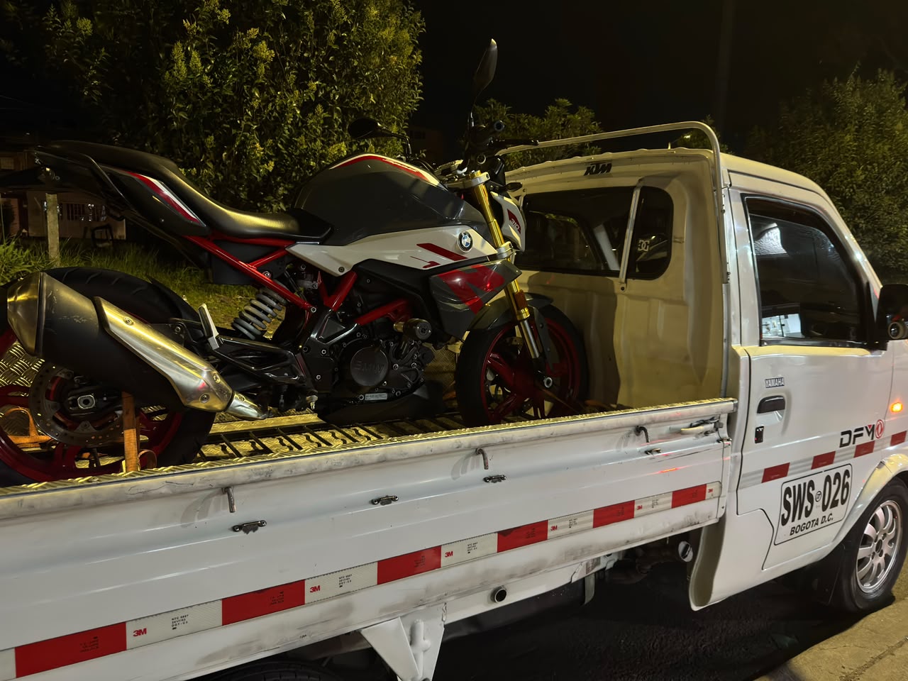 Servicio de grúa para motos de noche con varias motocicletas en Bogotá